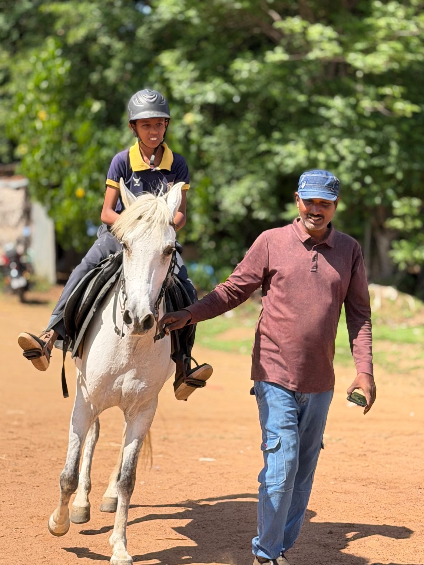 Trainer leading a mounted student during a horse riding lesson in Trichy